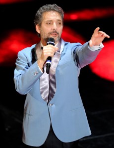 Sanremo, seconda serata con Bar e la Bruni. Poi tocca a Elio chierichetto, ed è subito show